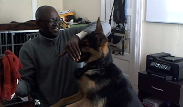 John Aghadiuno playing with pet, Hunter, the family top dog